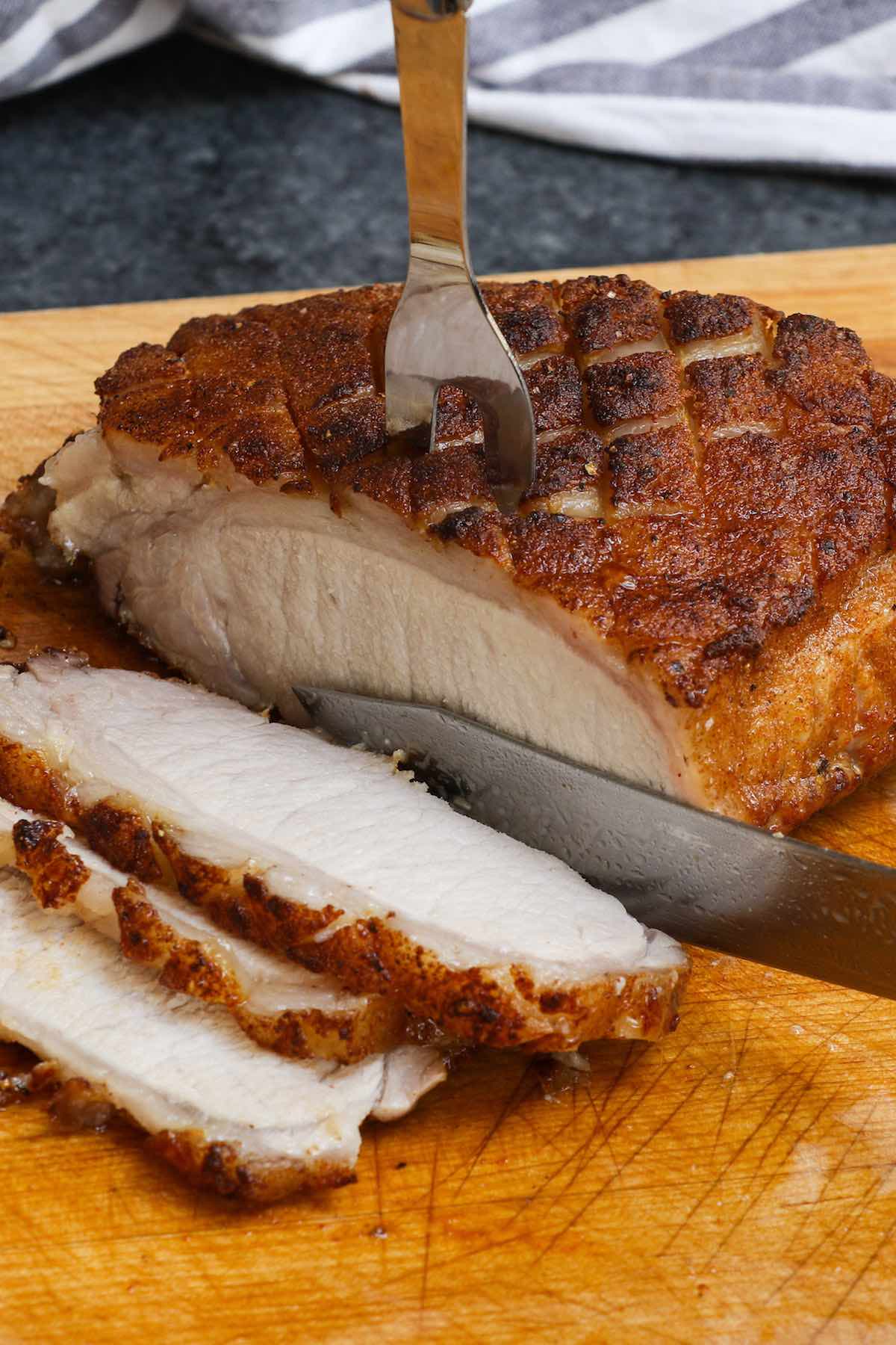Slicing a smoked pork loin on a carving board