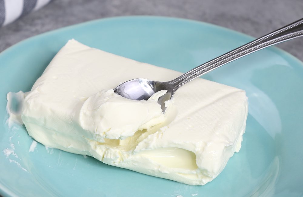 Spreading softened cream cheese on a plate