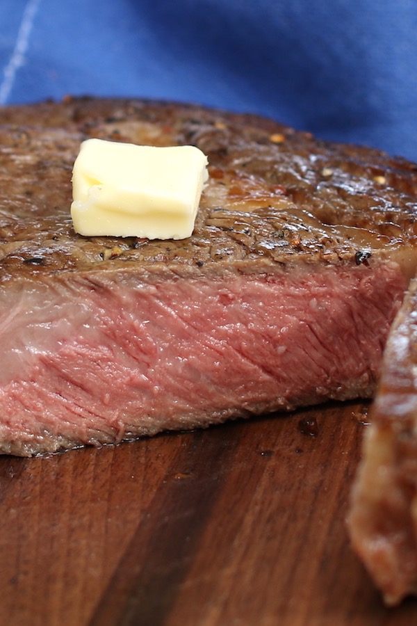 Sirloin steak seared to medium-rare, and resting on a cutting board
