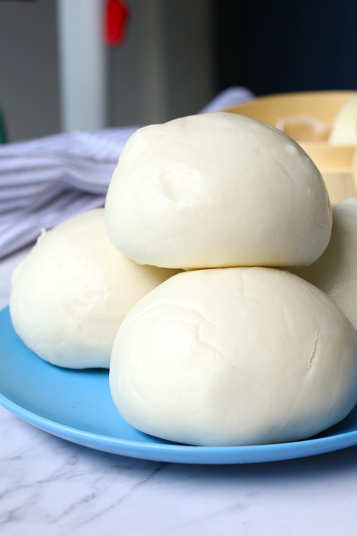 Freshly made steamed buns stacked on a serving plate ready to eat