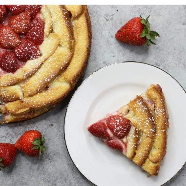 A slice of Strawberry Bread Pudding on a serving plate dusted with powdered sugar