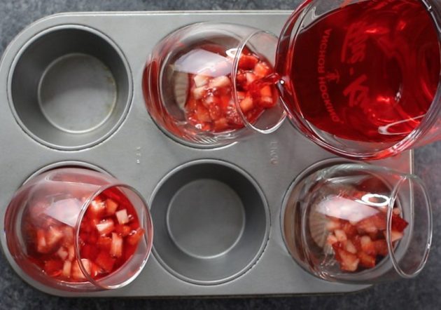 Strawberry Chocolate Mousse preparation by pouring jello into stemless wine glasses set on the diagonal in a muffin tin