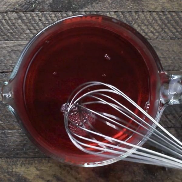 This is a photo of strawberry jello being made in a mixing cup