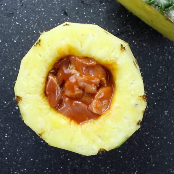 This photo shows a pineapple stuffed with marinated pork before being cooked into swineapple