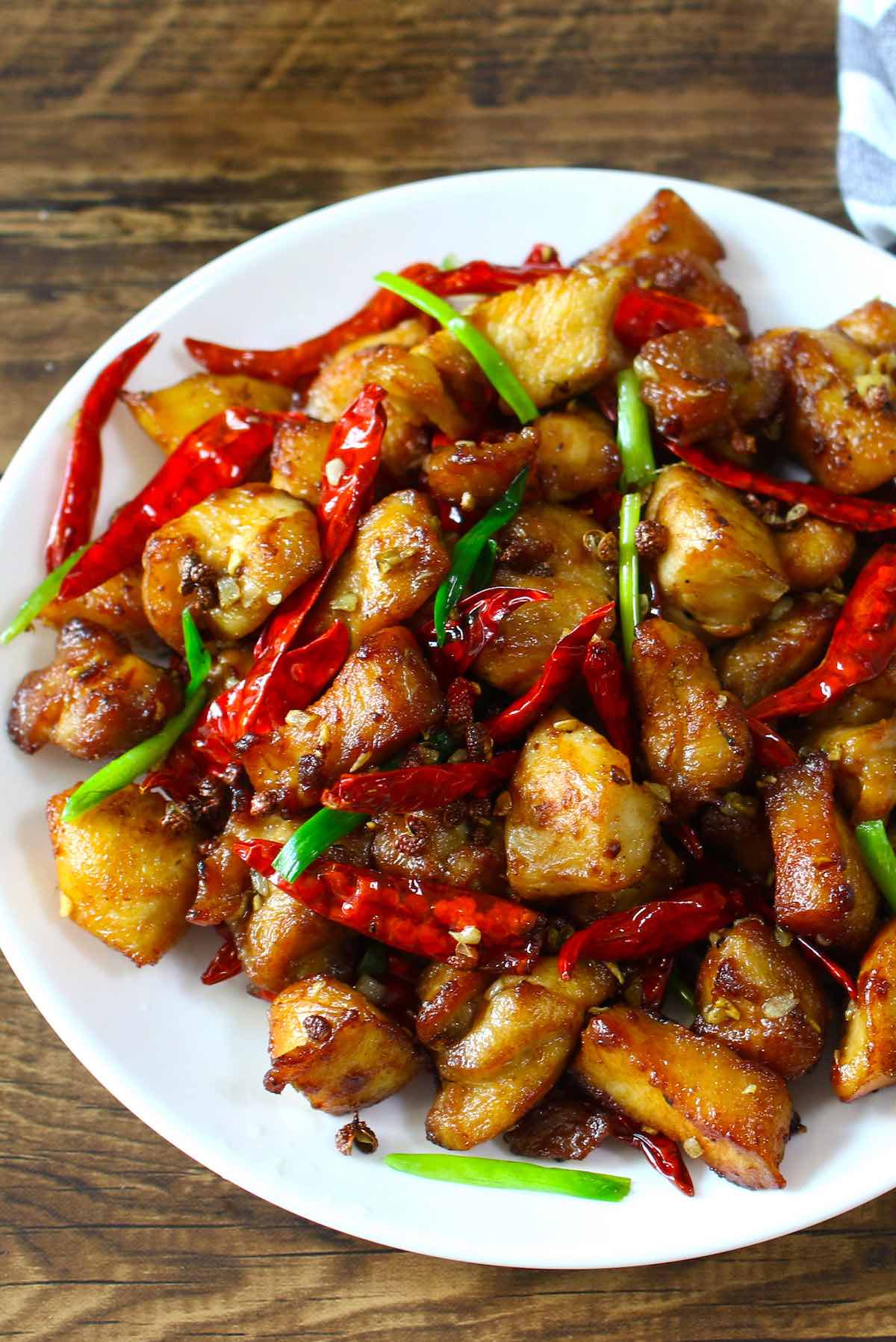 Szechuan chicken served on a white plate.