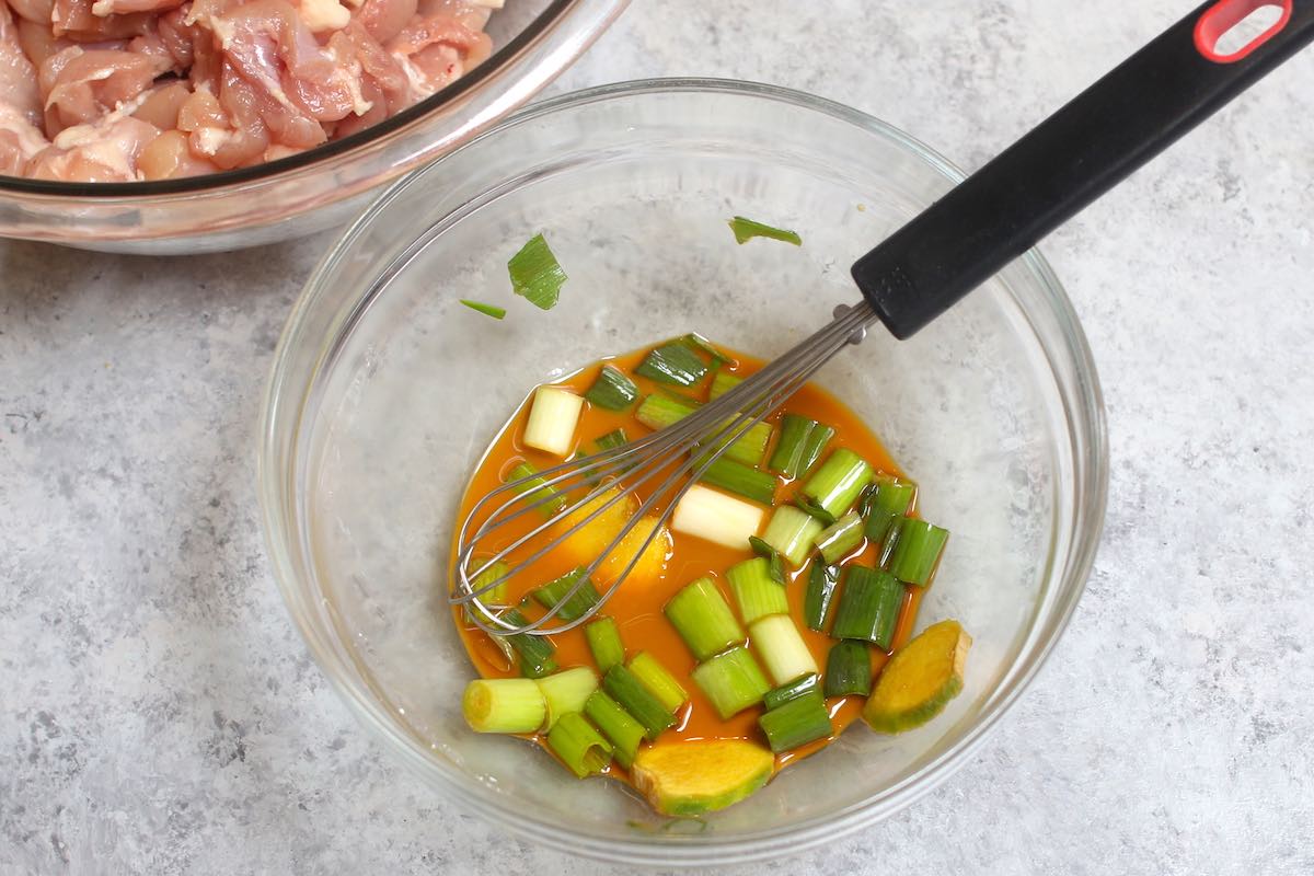 Making chicken marinate in a clear bowl.