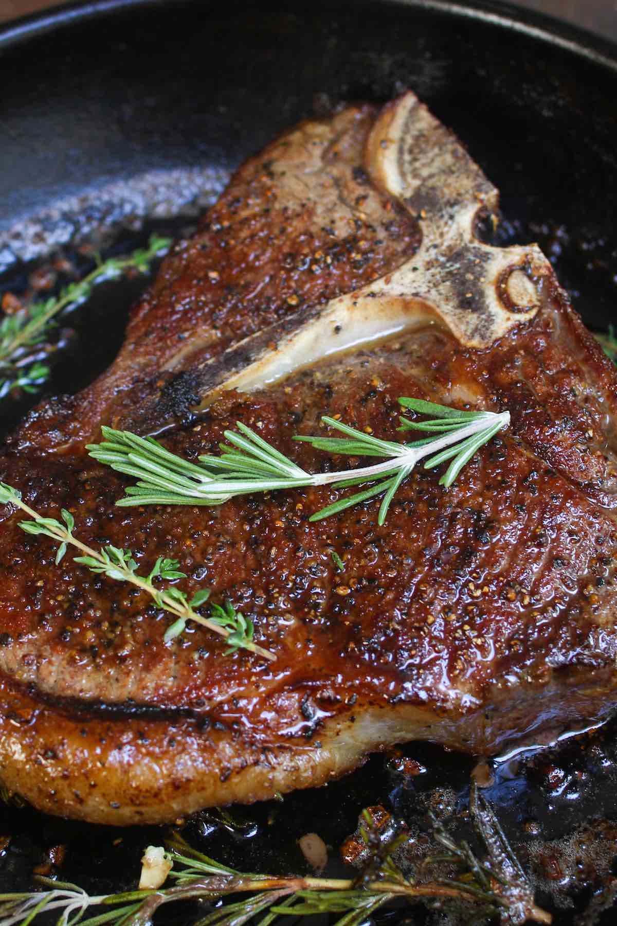 Perfectly seared Tbone steak in a cast iron skillet after being finished in the oven