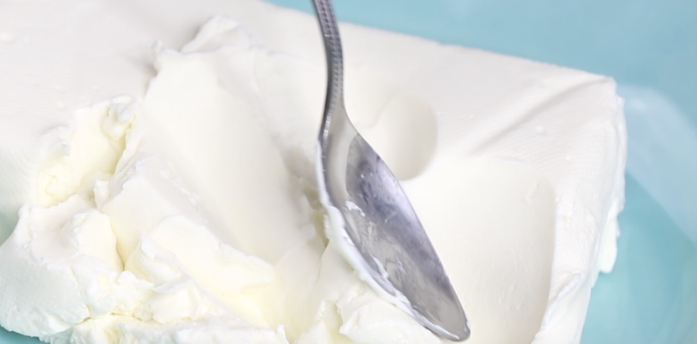 Closeup of softened cream cheese showing a spreadable consistency