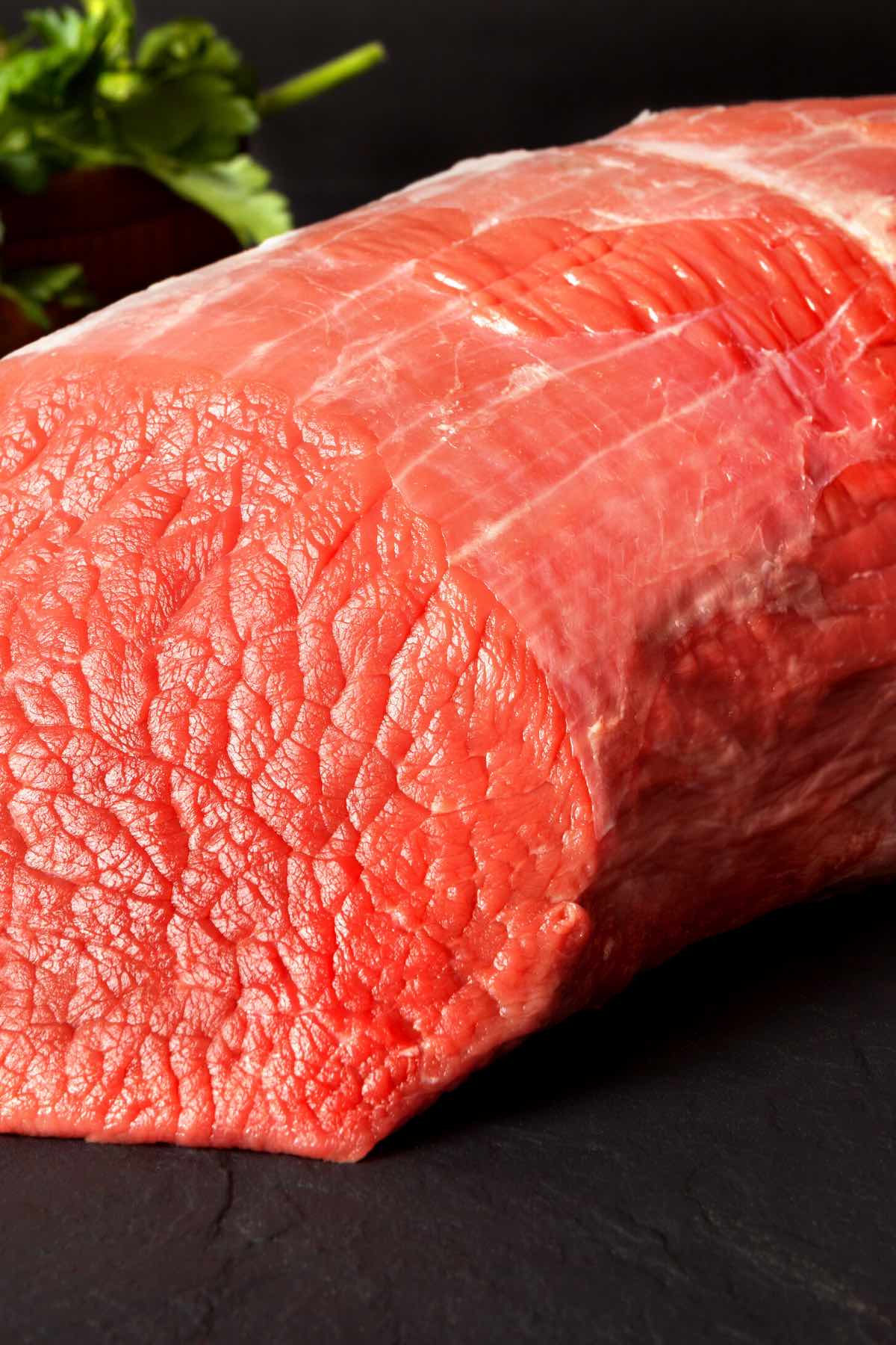 A raw piece of inside round roast that's lean and ready for roasting