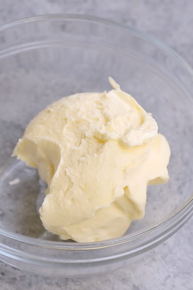 Softened butter in a clear bowl.