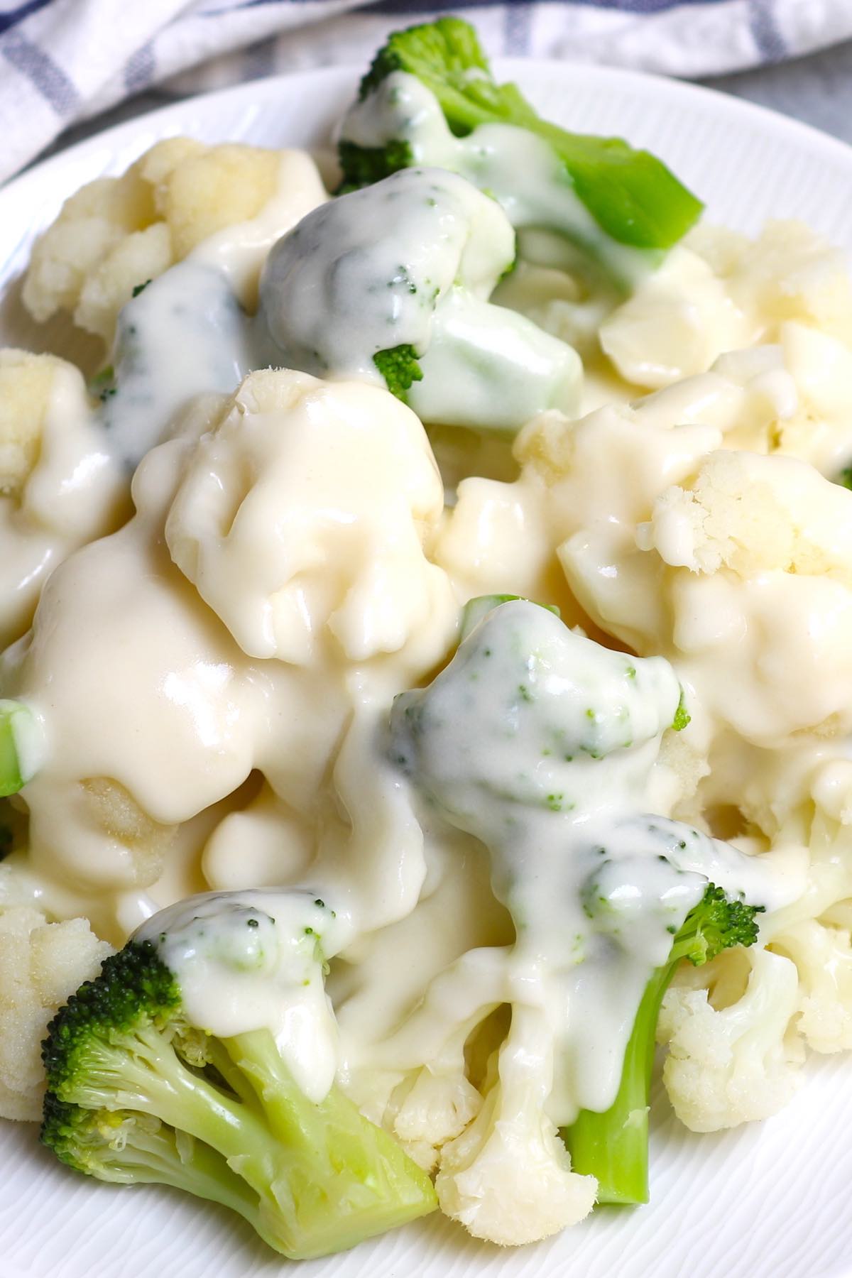 Steamed broccoli and cauliflower florets covered in cheddar sauce