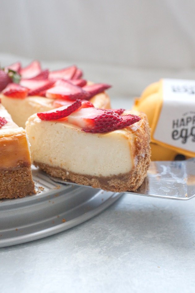 A slice of strawberry white chocolate cheesecake being served 