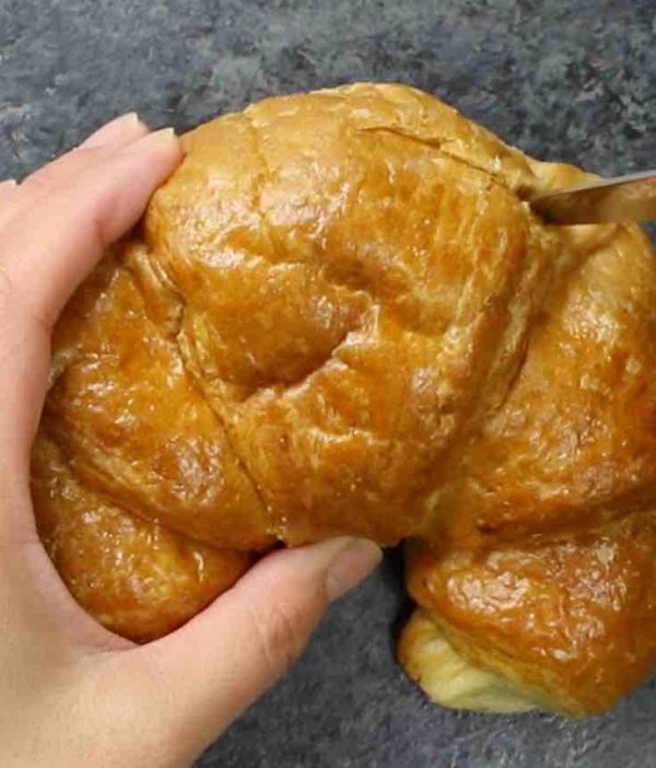 Cutting off the tops of croissants using a serrated knife