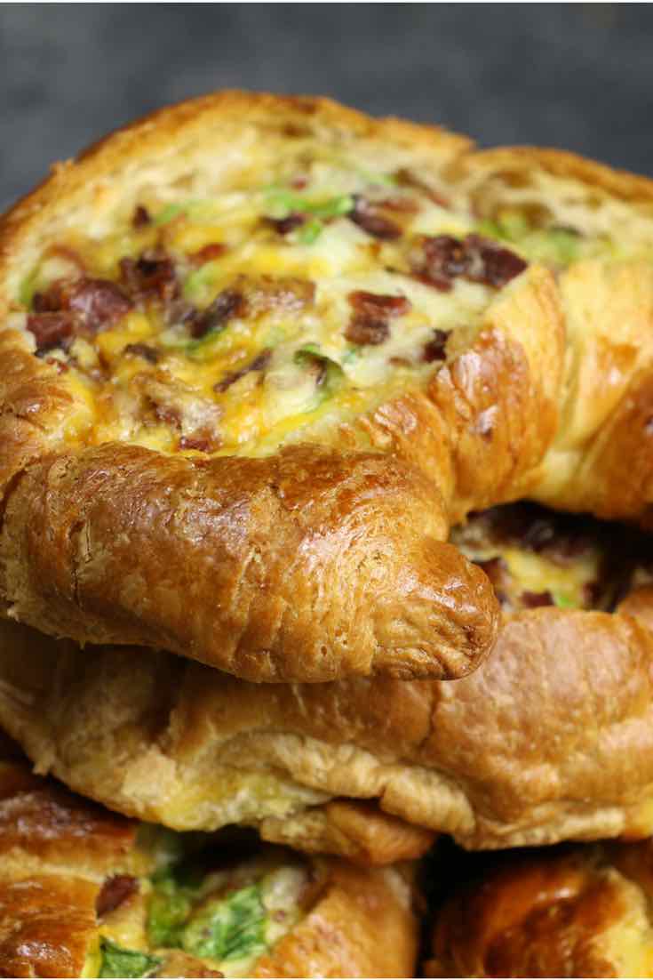 Cheesy Breakfast Croissant Boats – crispy bacon, fluffy egg and melted cheddar cheese baked in croissant breakfast boats! A quick and easy recipe that’s ready in 30 minutes and feeds a crowd! Perfect for breakfast and brunch. So delicious! Video recipe. | Tipbuzz.com